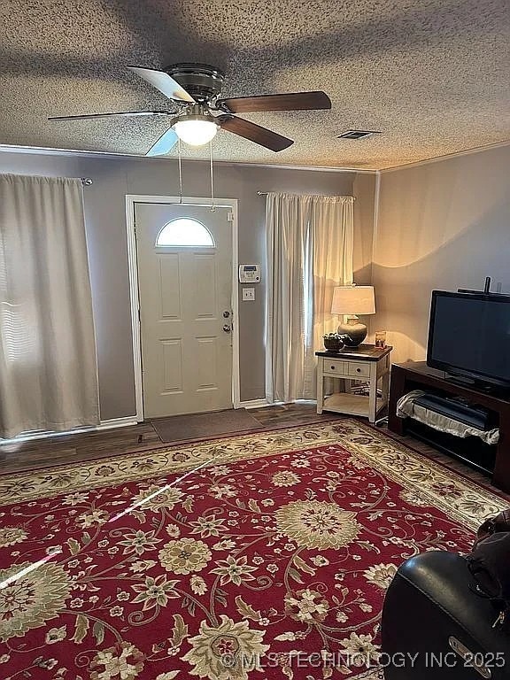 foyer with a textured ceiling and ceiling fan