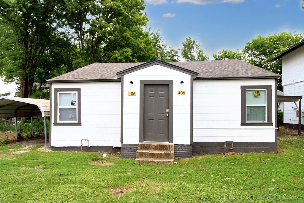 view of front of property with a front lawn and a carport