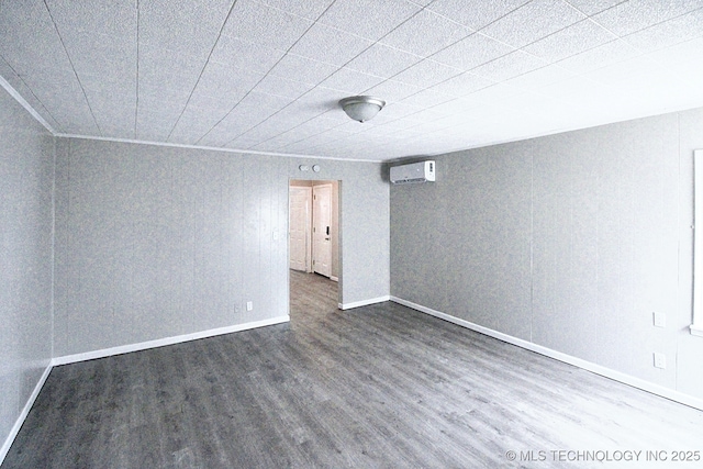 empty room featuring a wall mounted air conditioner and dark hardwood / wood-style floors