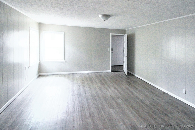 spare room featuring wood walls and dark hardwood / wood-style floors