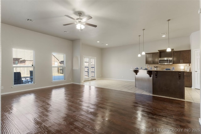 unfurnished living room featuring ceiling fan and light hardwood / wood-style flooring