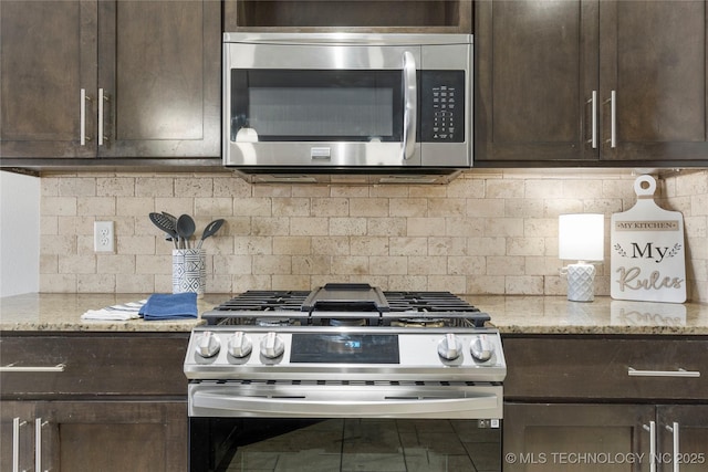 kitchen featuring stainless steel appliances, dark brown cabinetry, light stone countertops, and decorative backsplash