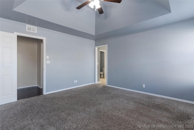 carpeted spare room featuring a high ceiling, ceiling fan, and a tray ceiling