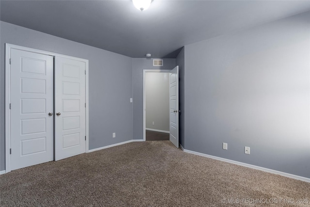 unfurnished bedroom with a closet and carpet flooring