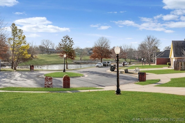 view of property's community featuring a yard and a water view