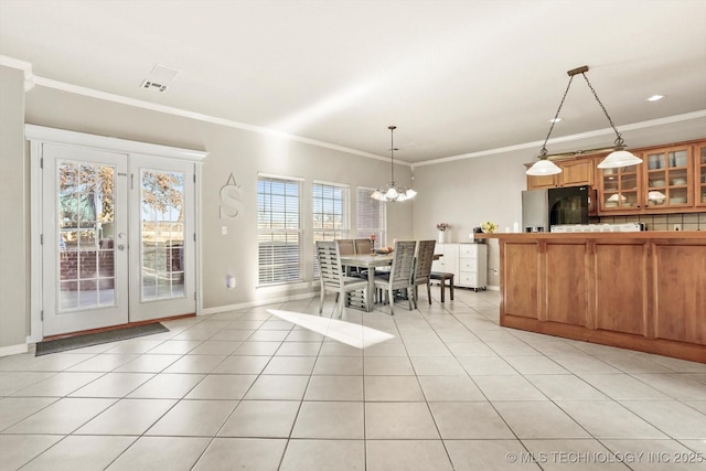 unfurnished dining area featuring ornamental molding, a chandelier, and light tile patterned floors