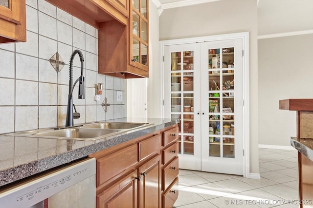 kitchen featuring sink, dishwasher, decorative backsplash, and light tile patterned floors