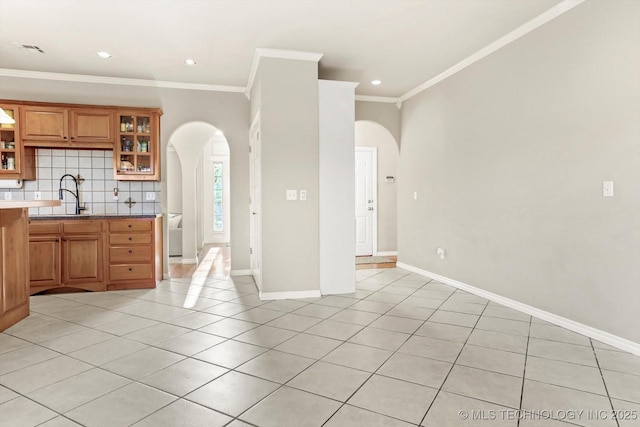 kitchen featuring sink, crown molding, tasteful backsplash, and light tile patterned floors