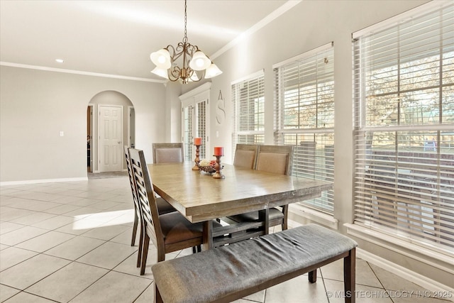 tiled dining area with crown molding and a chandelier