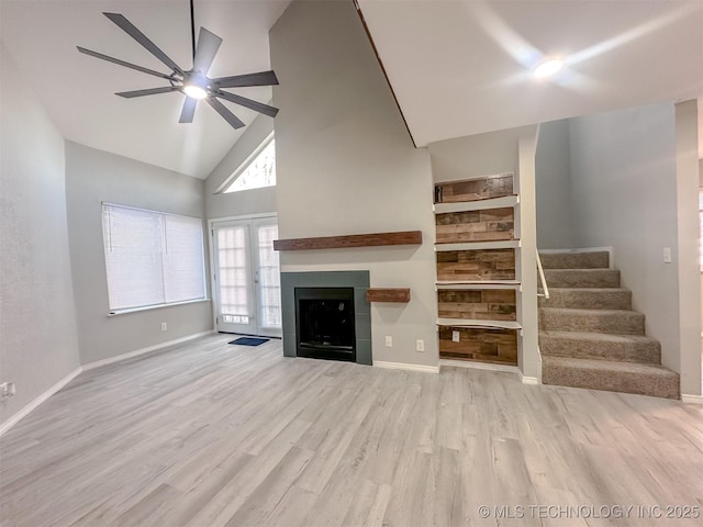 unfurnished living room with high vaulted ceiling, ceiling fan, and light hardwood / wood-style floors