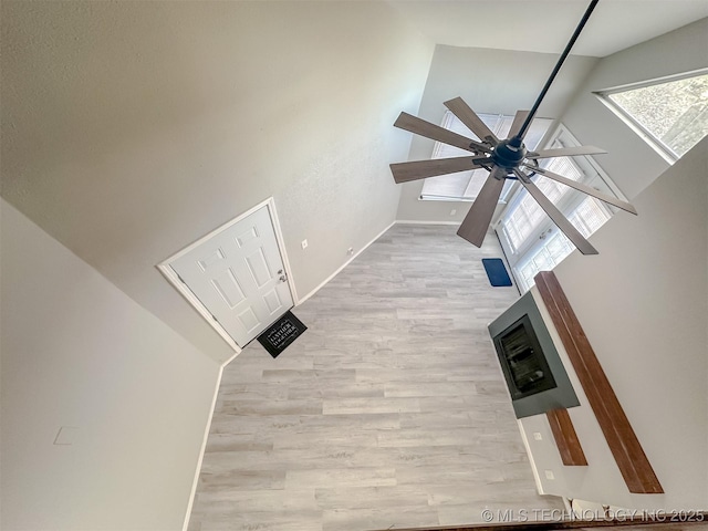 unfurnished living room featuring light wood-type flooring and a towering ceiling