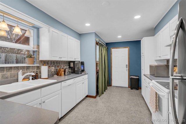 kitchen featuring white appliances, hanging light fixtures, white cabinetry, and sink