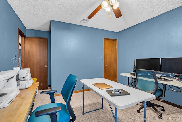 carpeted office space featuring ceiling fan and a textured ceiling