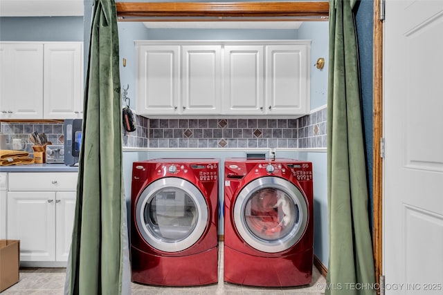 washroom featuring light tile patterned flooring, independent washer and dryer, and cabinets