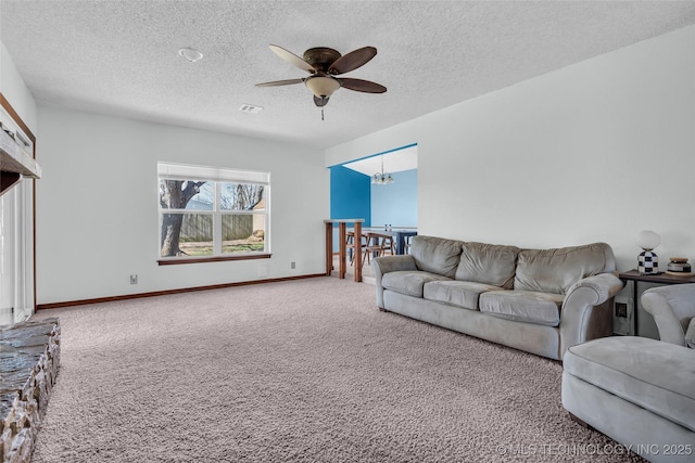 carpeted living room with a textured ceiling and ceiling fan with notable chandelier