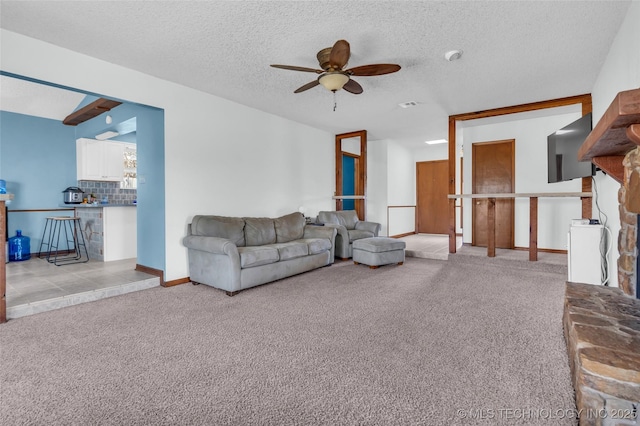 living room featuring ceiling fan, light carpet, and a textured ceiling