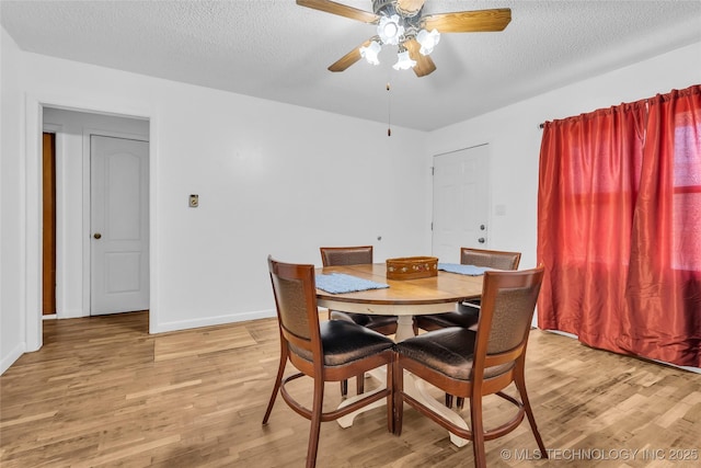 dining room featuring a textured ceiling, light wood-type flooring, and ceiling fan