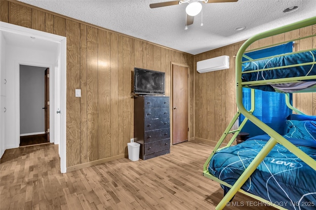 unfurnished bedroom featuring ceiling fan, a wall mounted air conditioner, and wooden walls