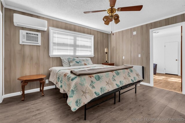 bedroom featuring ceiling fan, a wall unit AC, and hardwood / wood-style flooring