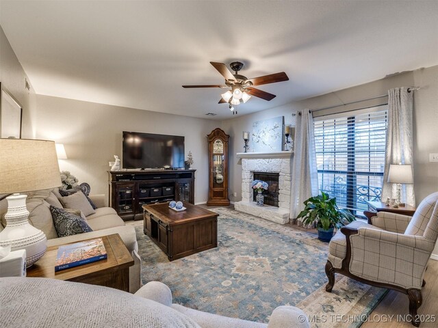 living room with ceiling fan, hardwood / wood-style floors, and a fireplace