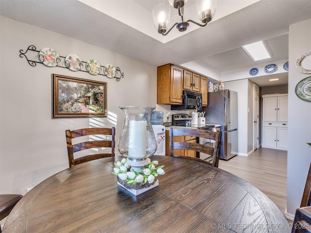 dining room featuring a notable chandelier and light hardwood / wood-style flooring