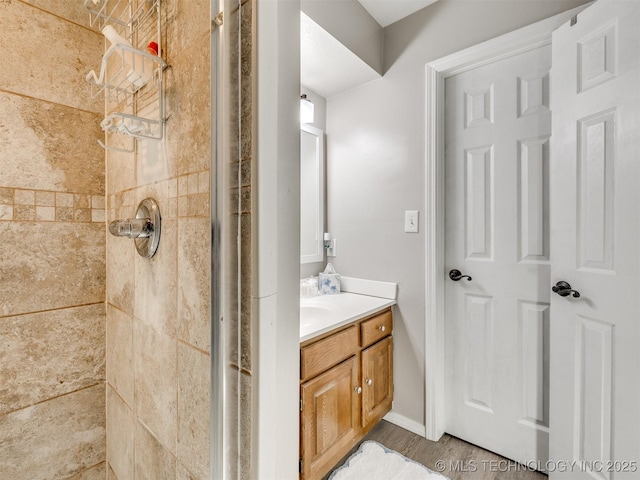 bathroom with a tile shower and vanity