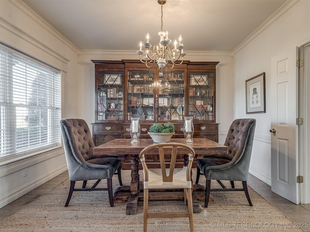 dining space featuring wood-type flooring, a healthy amount of sunlight, a chandelier, and ornamental molding