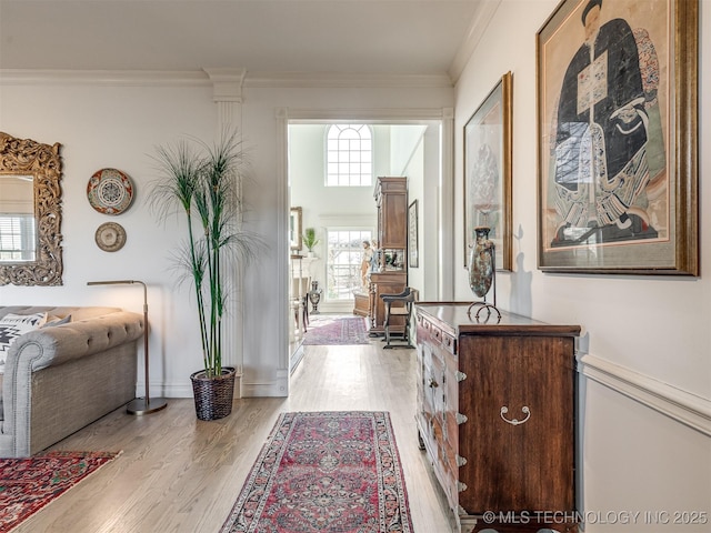 hallway featuring light hardwood / wood-style flooring and ornamental molding