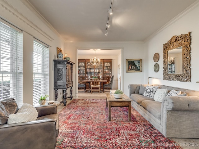 living room featuring ornamental molding, track lighting, and an inviting chandelier