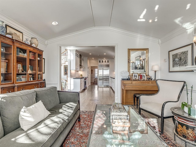 living room featuring crown molding, light hardwood / wood-style flooring, and lofted ceiling