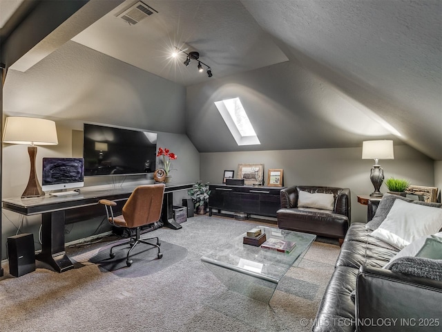 carpeted home office featuring vaulted ceiling with skylight and a textured ceiling