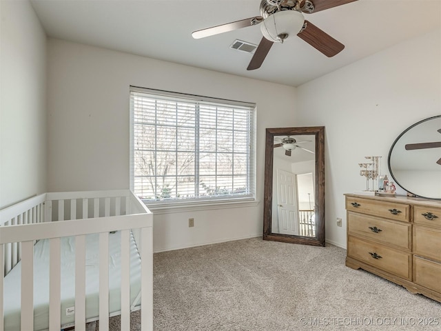 bedroom featuring ceiling fan, a nursery area, light carpet, and multiple windows