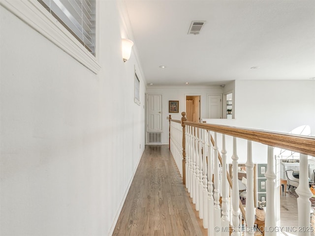 hallway with hardwood / wood-style flooring and ornamental molding