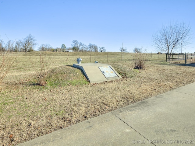 entry to storm shelter with a lawn and a rural view