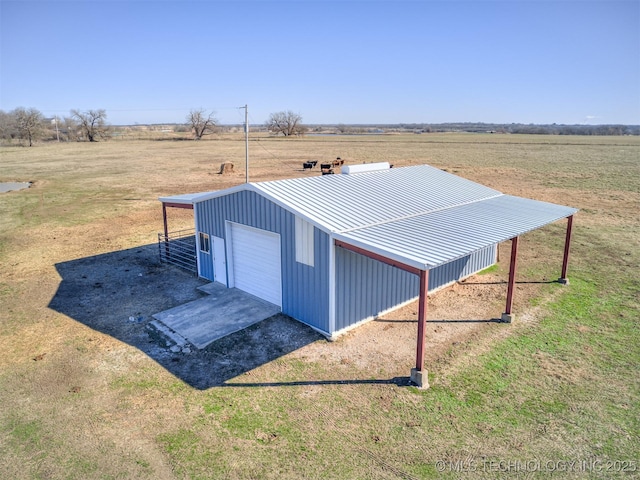 view of outbuilding featuring a yard, a garage, and a rural view