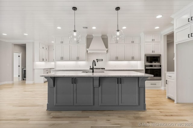 4006 S Dogwood Pl, Broken Arrow, OK 74012 - kitchen featuring stainless steel appliances, custom range hood, a sink, white cabinets, and gray cabinetry