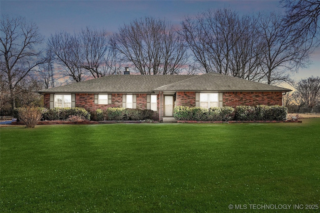 ranch-style home featuring a lawn