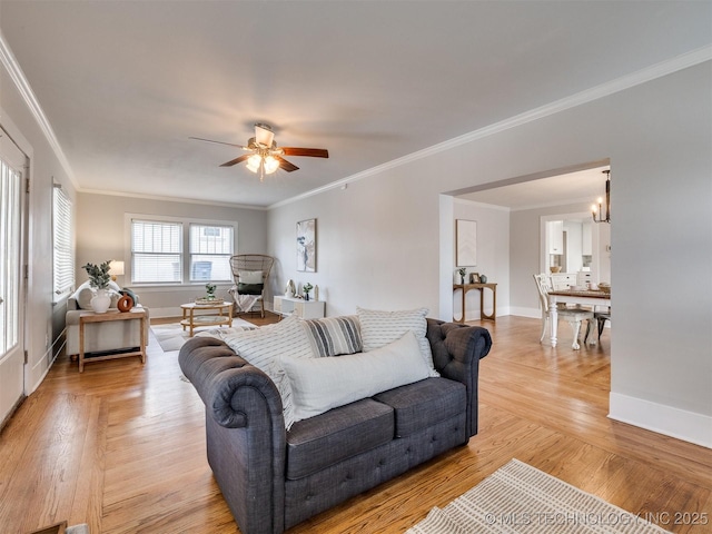 living room featuring ornamental molding, light wood-type flooring, and ceiling fan with notable chandelier