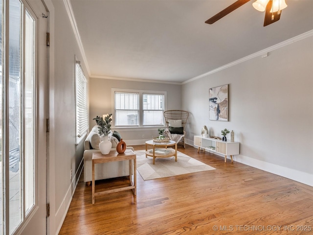 living area with ceiling fan, ornamental molding, and wood-type flooring