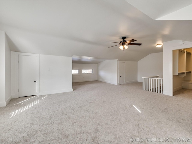 additional living space with lofted ceiling, light colored carpet, and ceiling fan