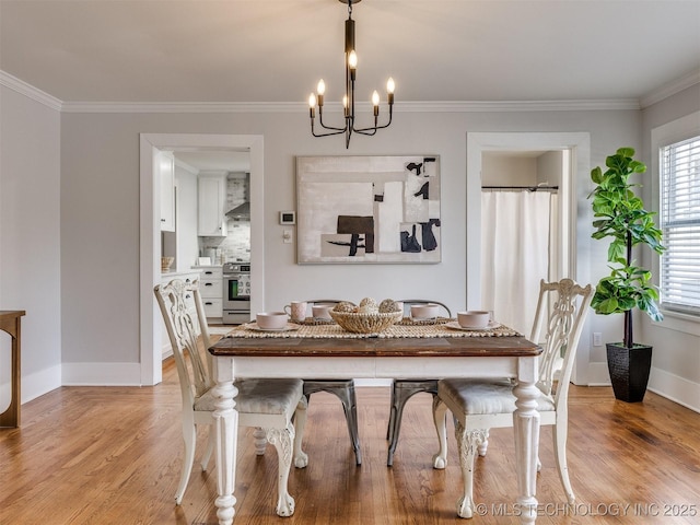 dining space featuring light hardwood / wood-style floors, an inviting chandelier, ornamental molding, and a healthy amount of sunlight