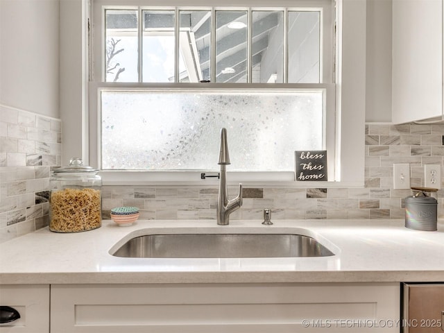 kitchen with sink, white cabinetry, and tasteful backsplash