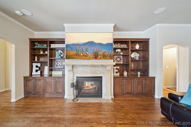 living room featuring a tile fireplace, crown molding, and hardwood / wood-style floors