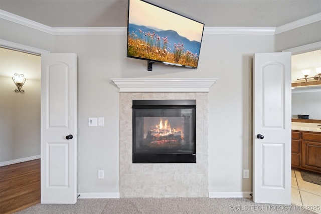 details featuring a tile fireplace, crown molding, and carpet flooring