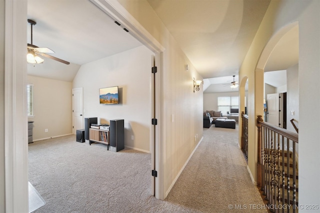 hallway with light colored carpet and vaulted ceiling