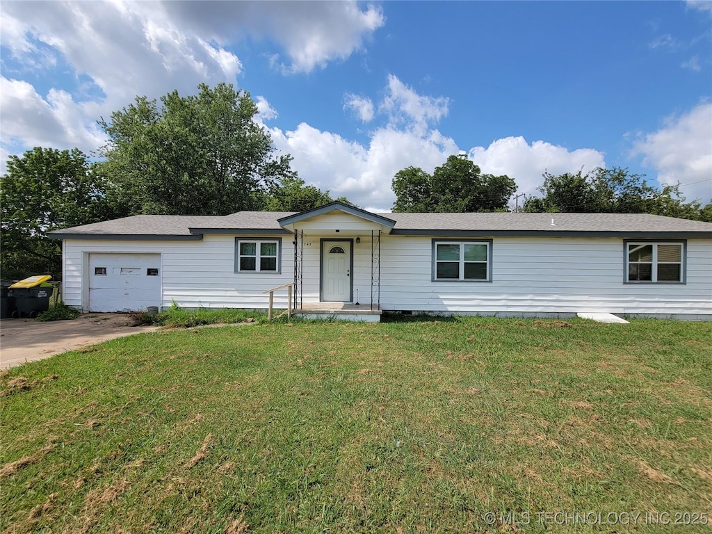 single story home featuring a front lawn and a garage