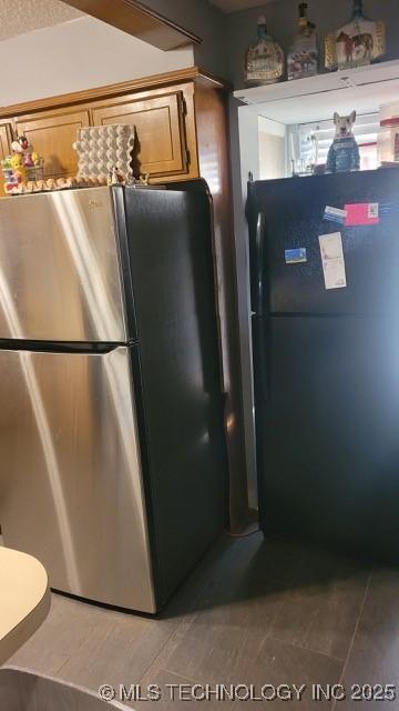 kitchen featuring black fridge and stainless steel refrigerator