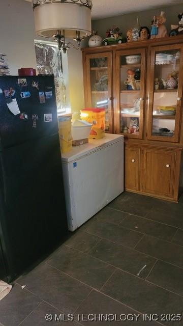 kitchen with black fridge and washer / clothes dryer