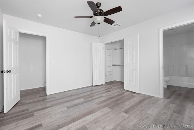 unfurnished bedroom featuring ceiling fan, light hardwood / wood-style flooring, connected bathroom, and a closet