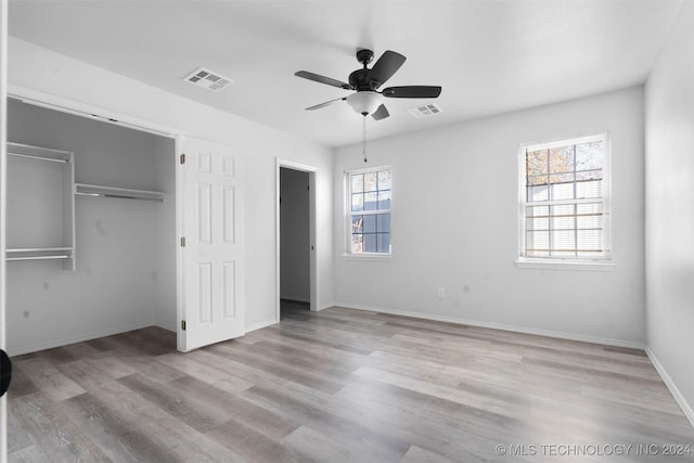 unfurnished bedroom with multiple windows, a closet, ceiling fan, and light hardwood / wood-style floors